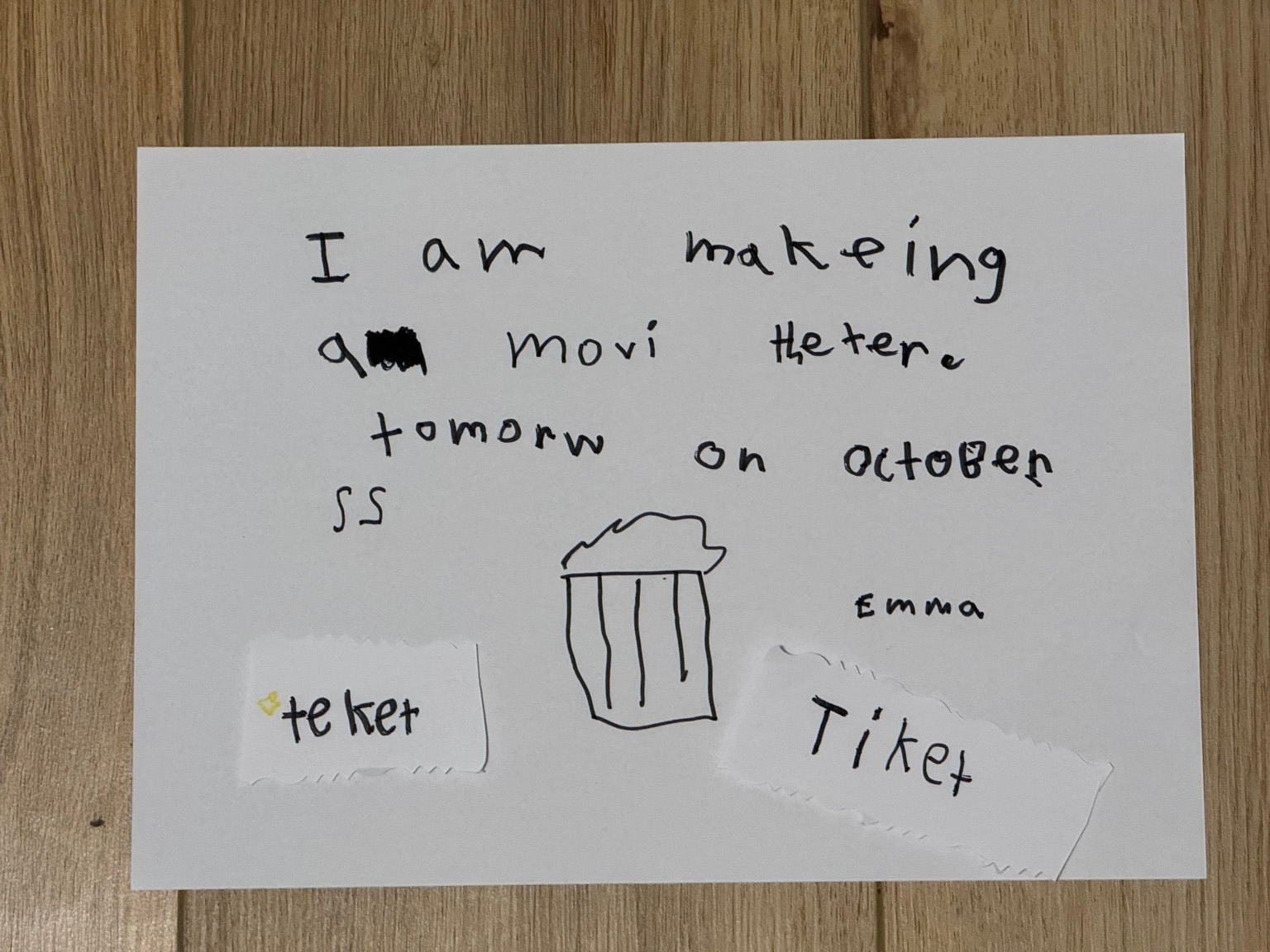 A handwritten note announcing a movie theater tomorrow, with a drawing of popcorn and two handmade tickets.